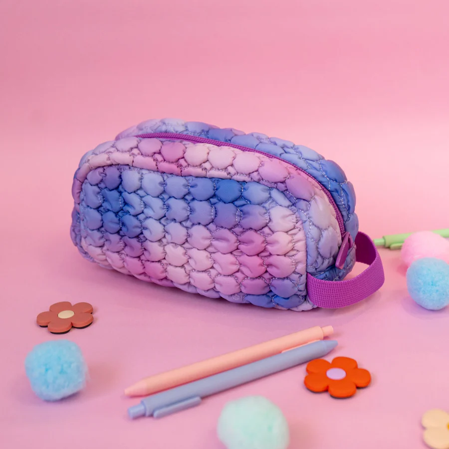 Multicolored textured pouch with stationery items on a pink background