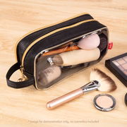 Black cosmetic bag with makeup items on a wooden surface