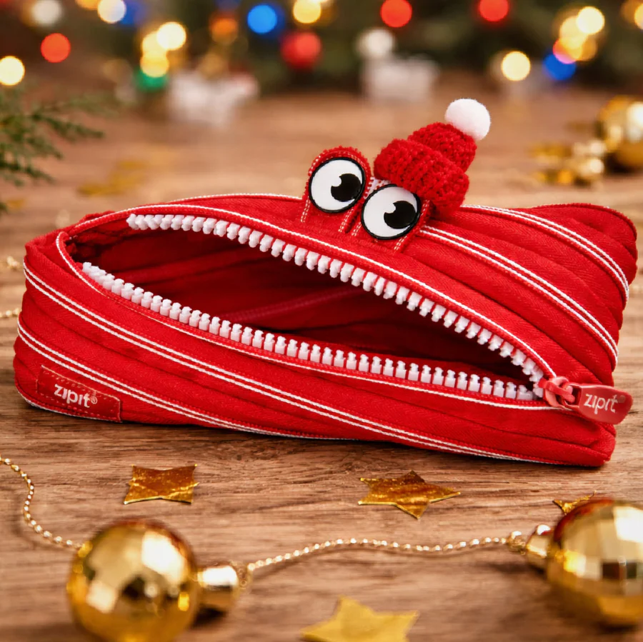 Red zipper pouch with a cartoon face on a wooden surface with festive decorations.
