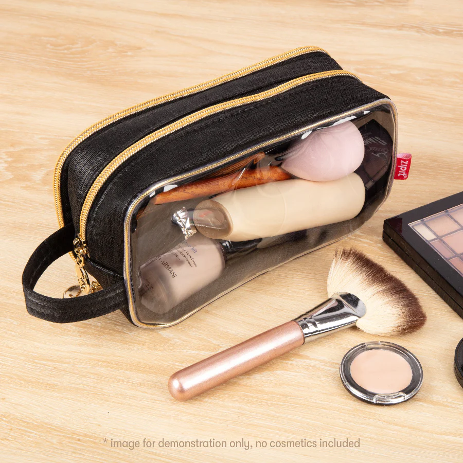 Black cosmetic bag with makeup items on a wooden surface