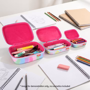 Pink pencil case with stationery items on a desk with notebooks and pencils.